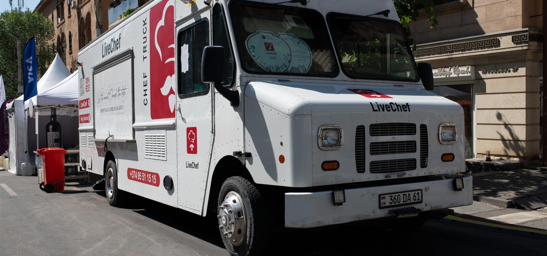 White food truck serving customers at a bustling outdoor street festival