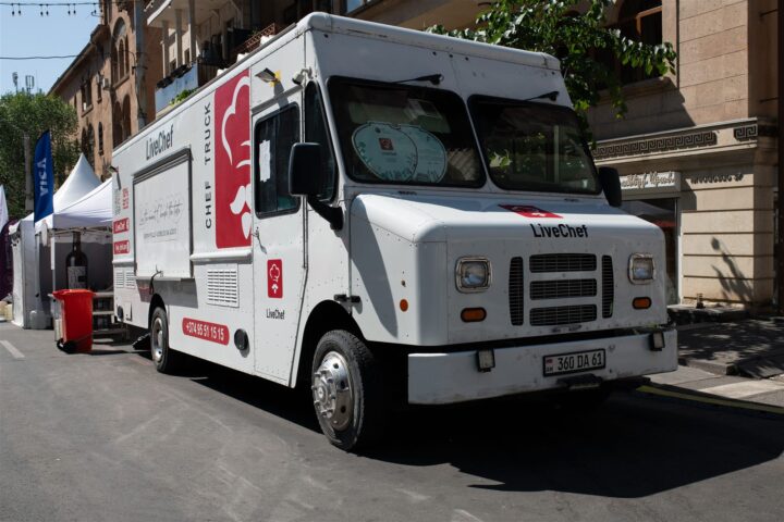 White food truck serving customers at a bustling outdoor street festival