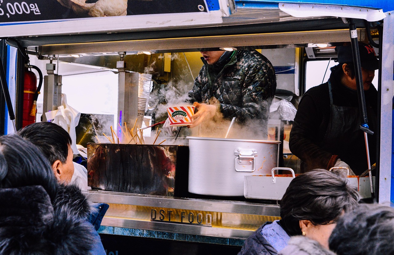 Street food vendor cooking and serving customers from a mobile food stand outdoors